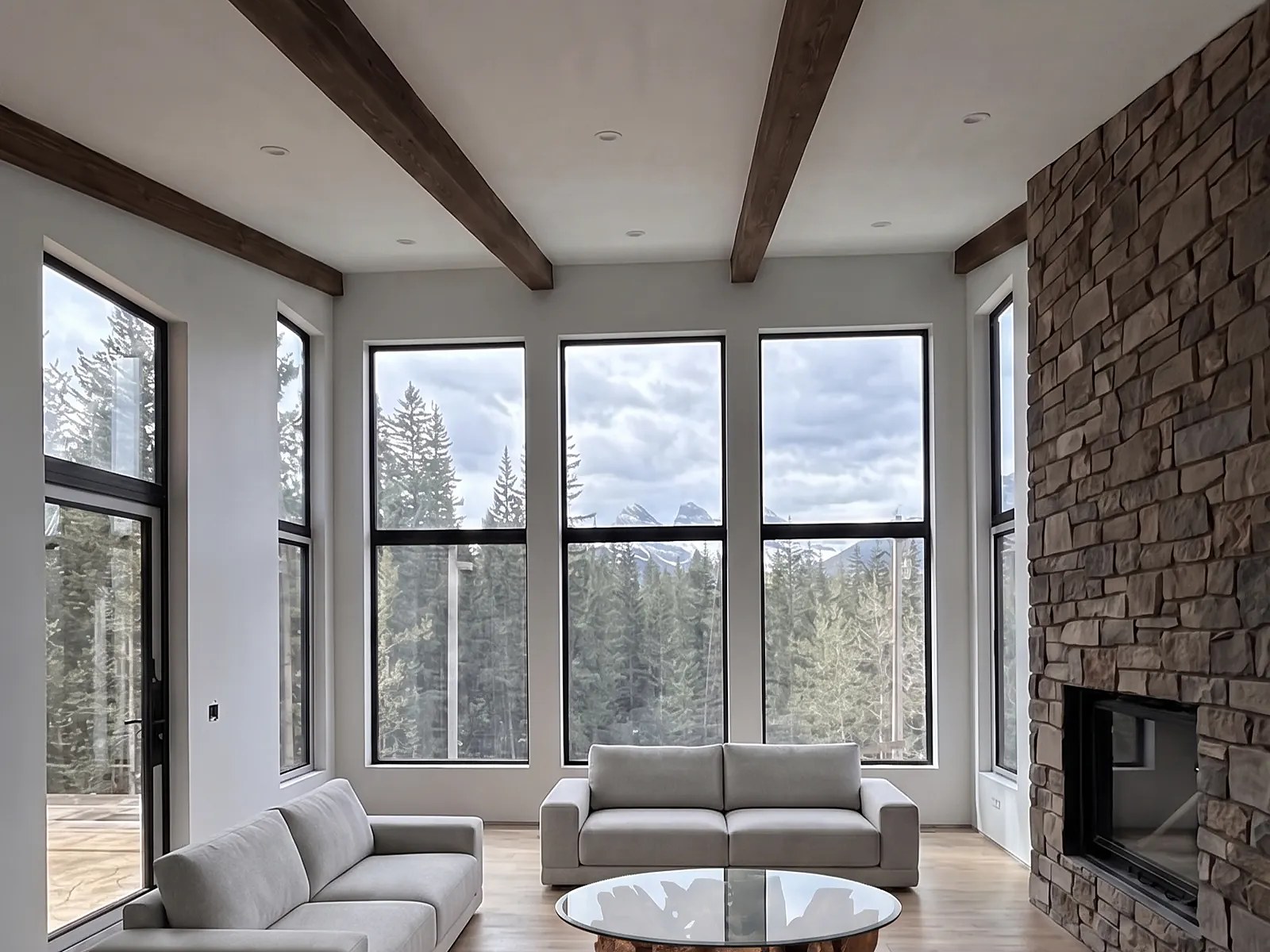 The great room at Serenity Point, with large south-facing windows to the Three Sisters and a stone fireplace.