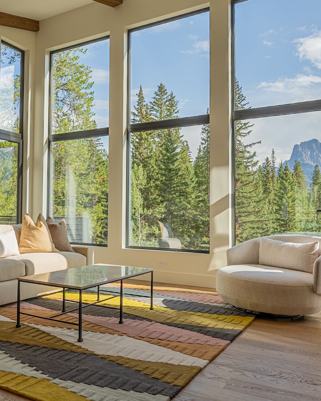 The great room, the sofa and the swivel chair at the windows, a peak beyond
