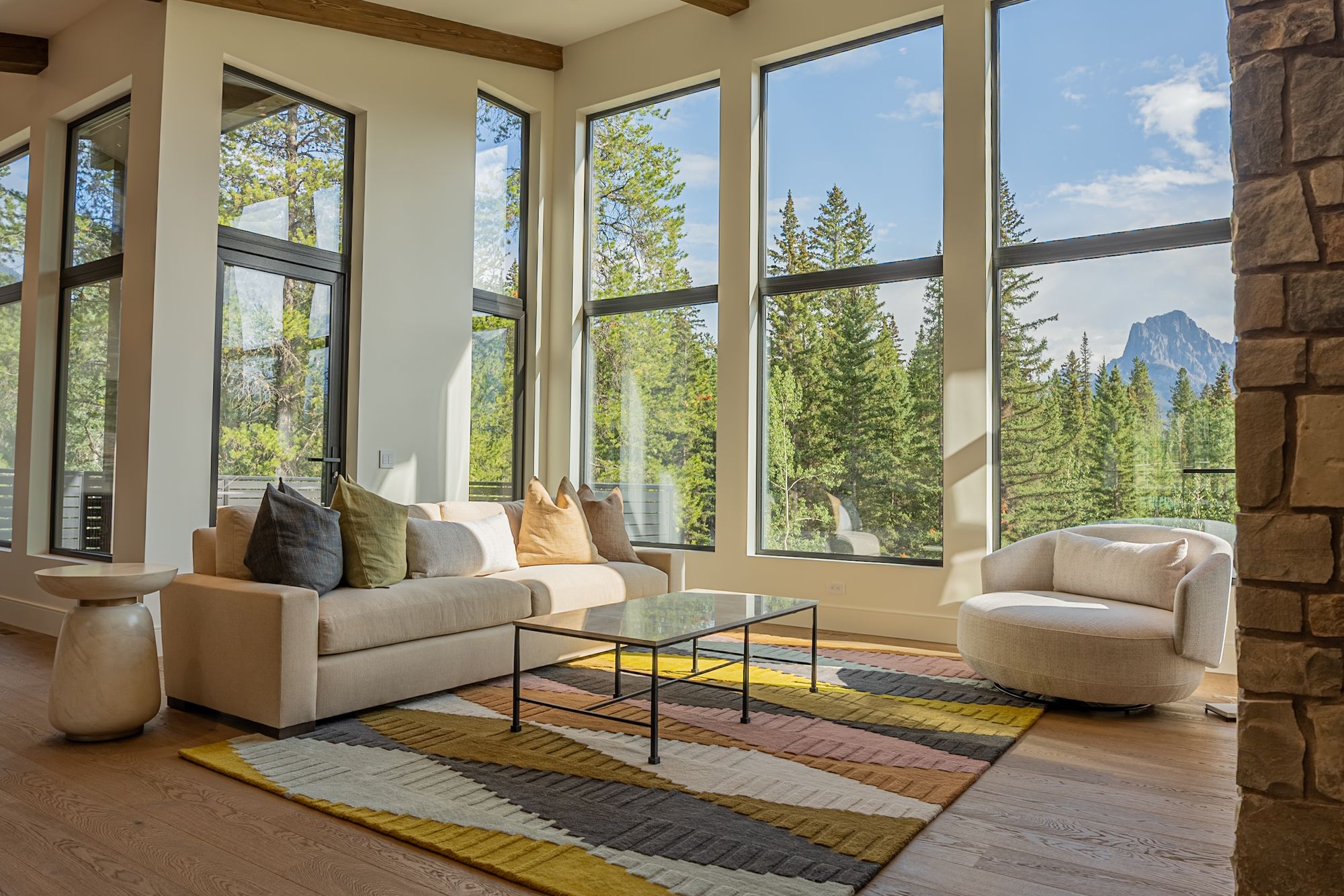 The great room, the sofa and the swivel chair at the windows, a peak beyond