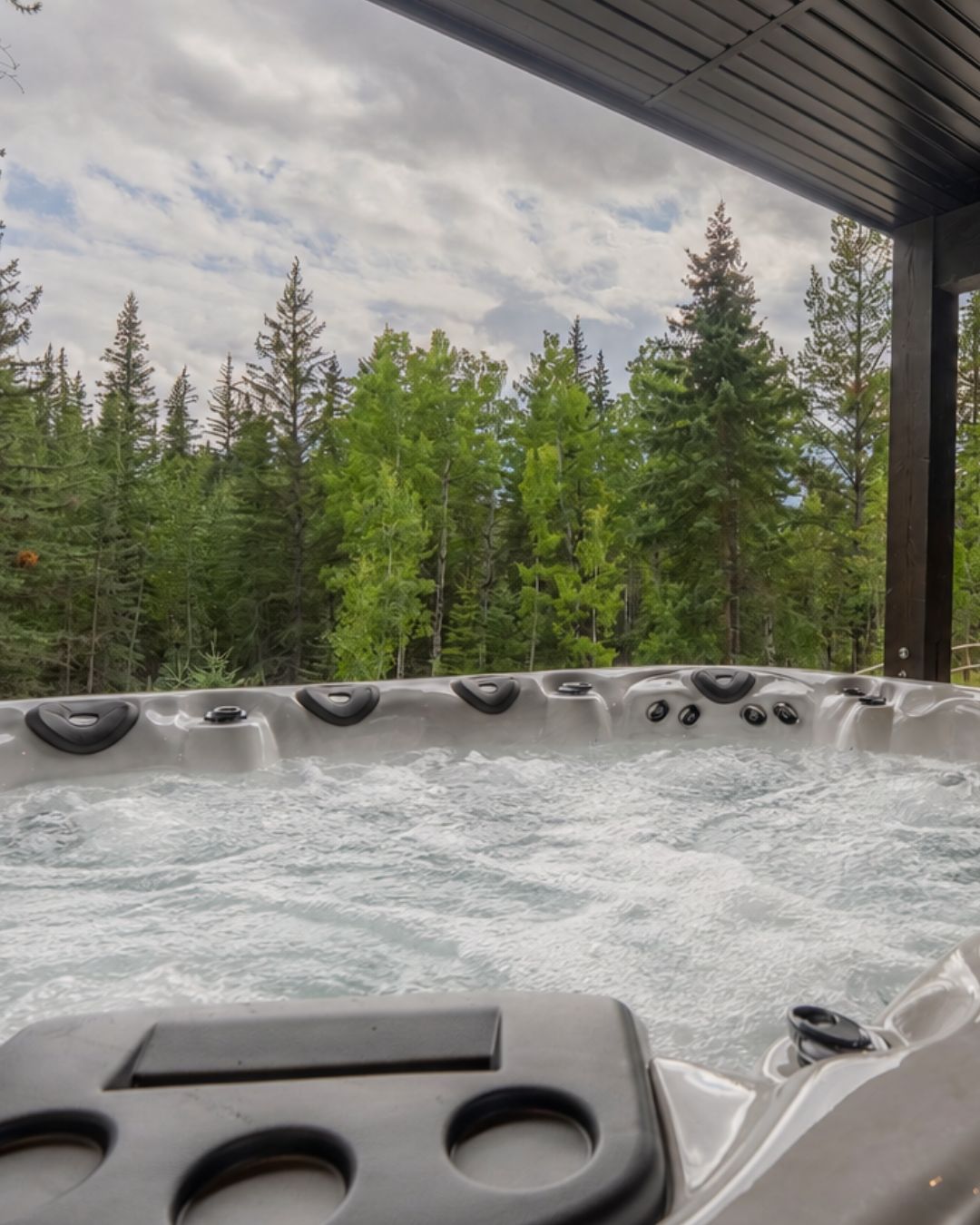 The hot tub on the lower deck, facing the forest