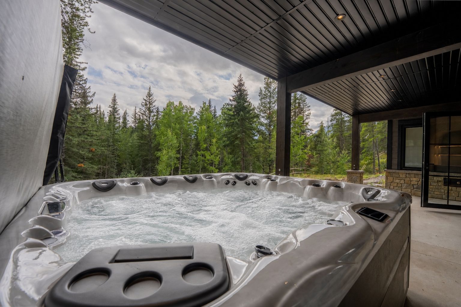 The hot tub on the lower deck, facing the forest