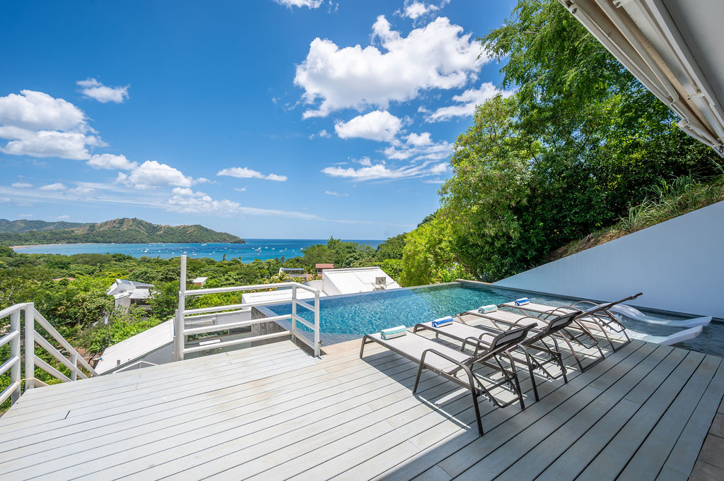Pool deck with loungers looking out toward the bay
